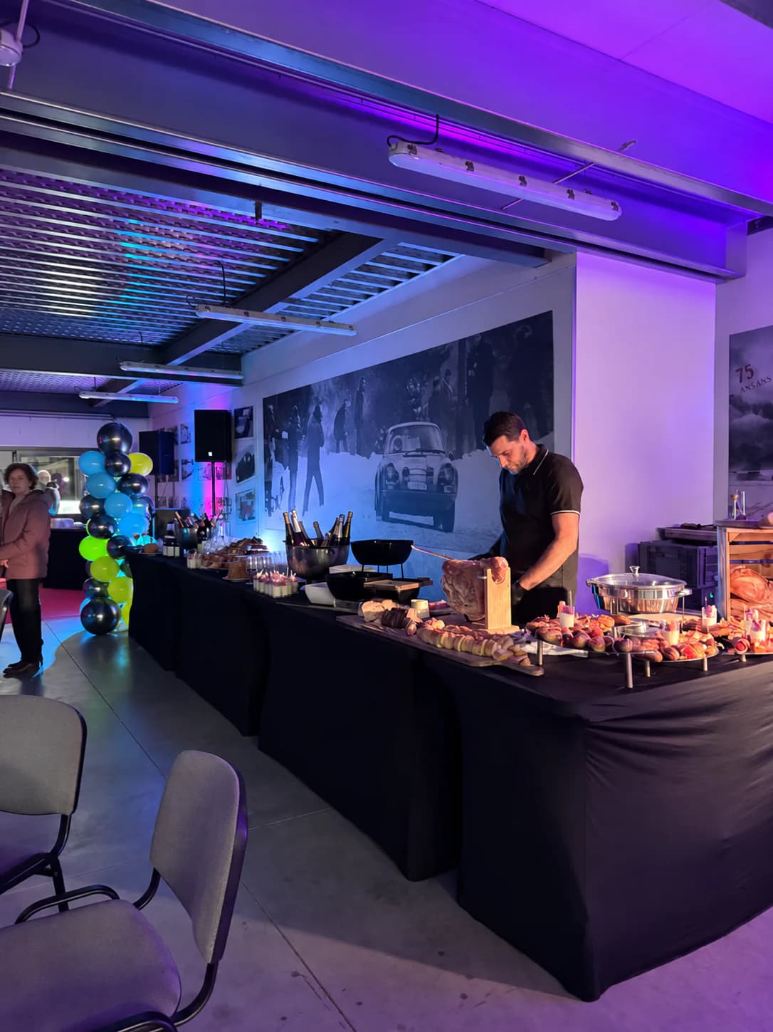 Chef derrière un buffet de soirée d'entreprise sous un éclairage violet