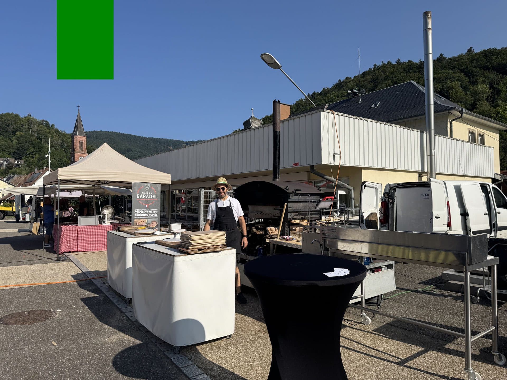 Stand de cuisson avec four à bois mobile installé sur une place extérieure
