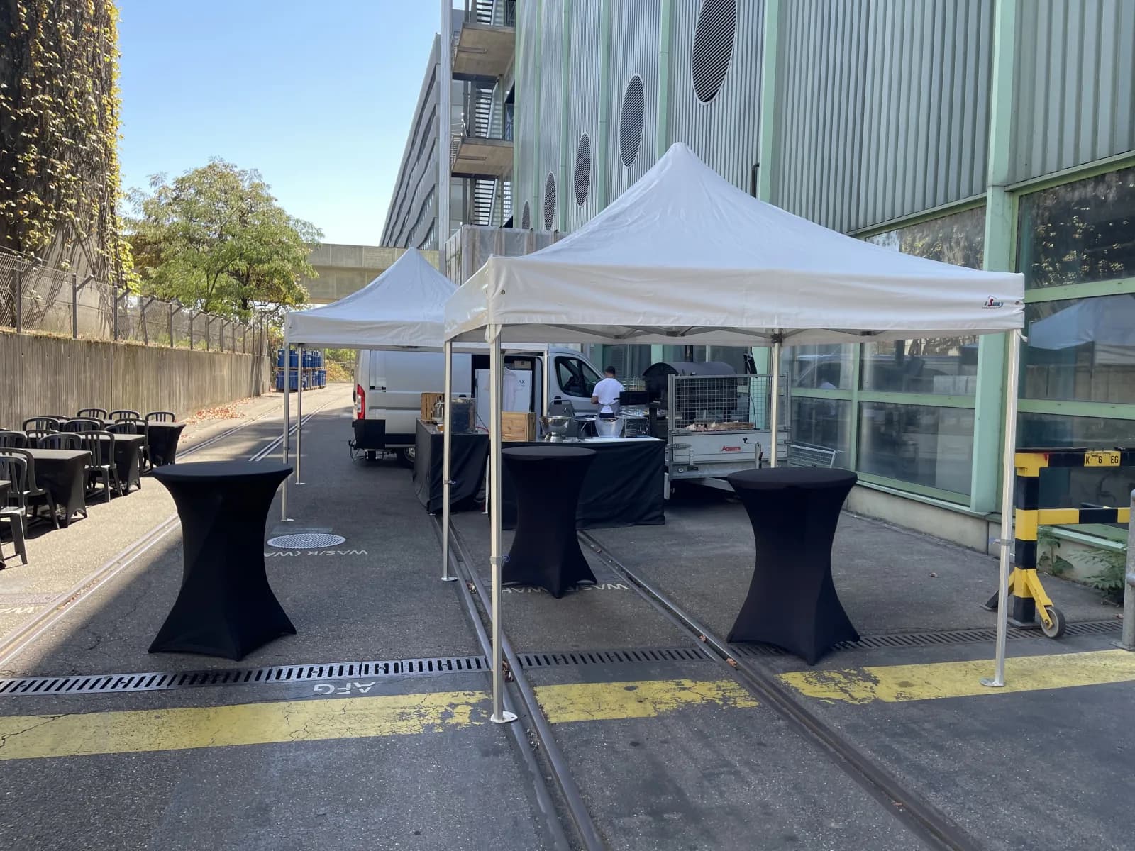 Barnums, mange-debout et chaises installés devant les locaux d’une entreprise